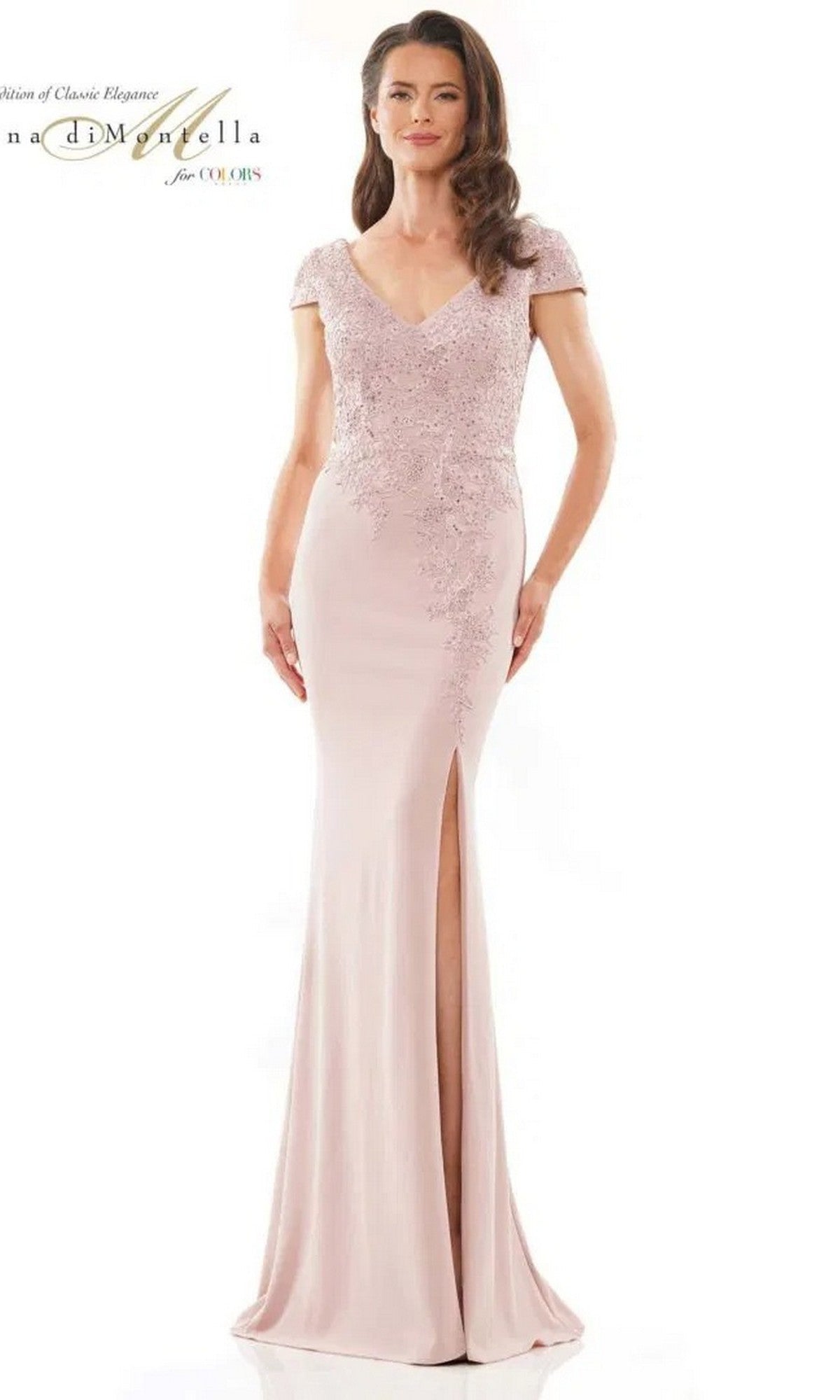 A woman wears the Rina Di Montella RD2763 long formal dress in rose, featuring an embroidered bodice, short sleeves, and a thigh-high slit on the sheath skirt, standing against a plain white background.